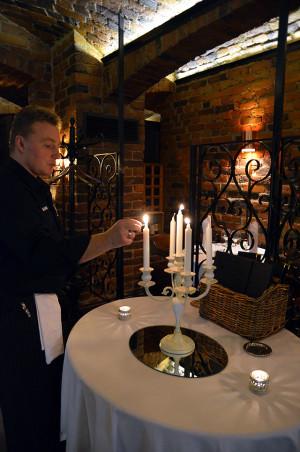 Hovimestari Mika Lintula sytyttää kynttilät ja asiakkaiden mielenkiinnon Tiiliholvin huikeaa juomatuotetta kohtaan.