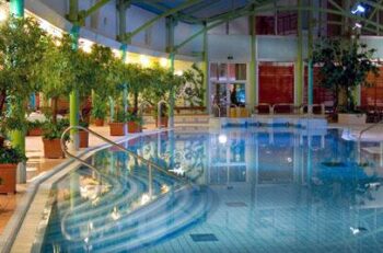 Holiday Club Tampereen kylpylän uima-allas iltavalaistuksessa.