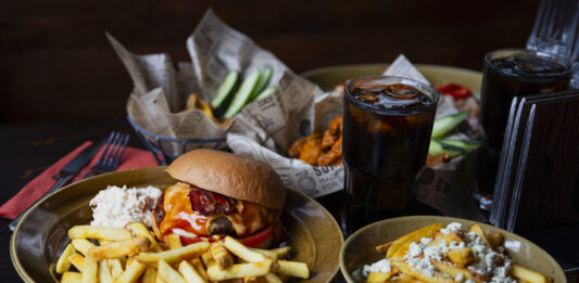 Zarillo-ravintolan valikoimaa: burger-annos ranskalaisilla ja siipiateria korissa lisukkeineen.