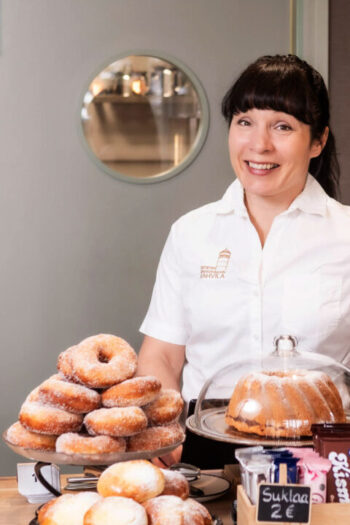Koponen tarjoilee munkkeja Kirkkoharjun jugend-näkötornin juurella. Kuva Kirkkoharjun Kahvila.