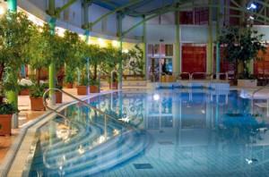 Holiday Club Tampereen kylpylän uima-allas iltavalaistuksessa.